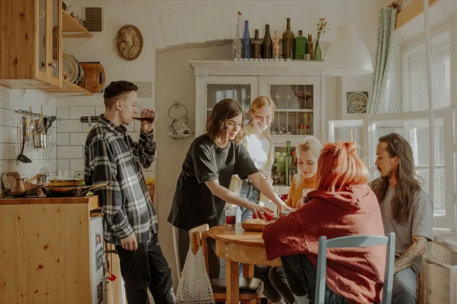 Varias personas cocinando y sirviendo en una cocina.
